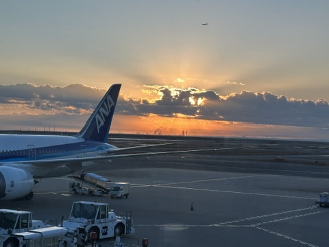 朝日が昇る空港と旅客機